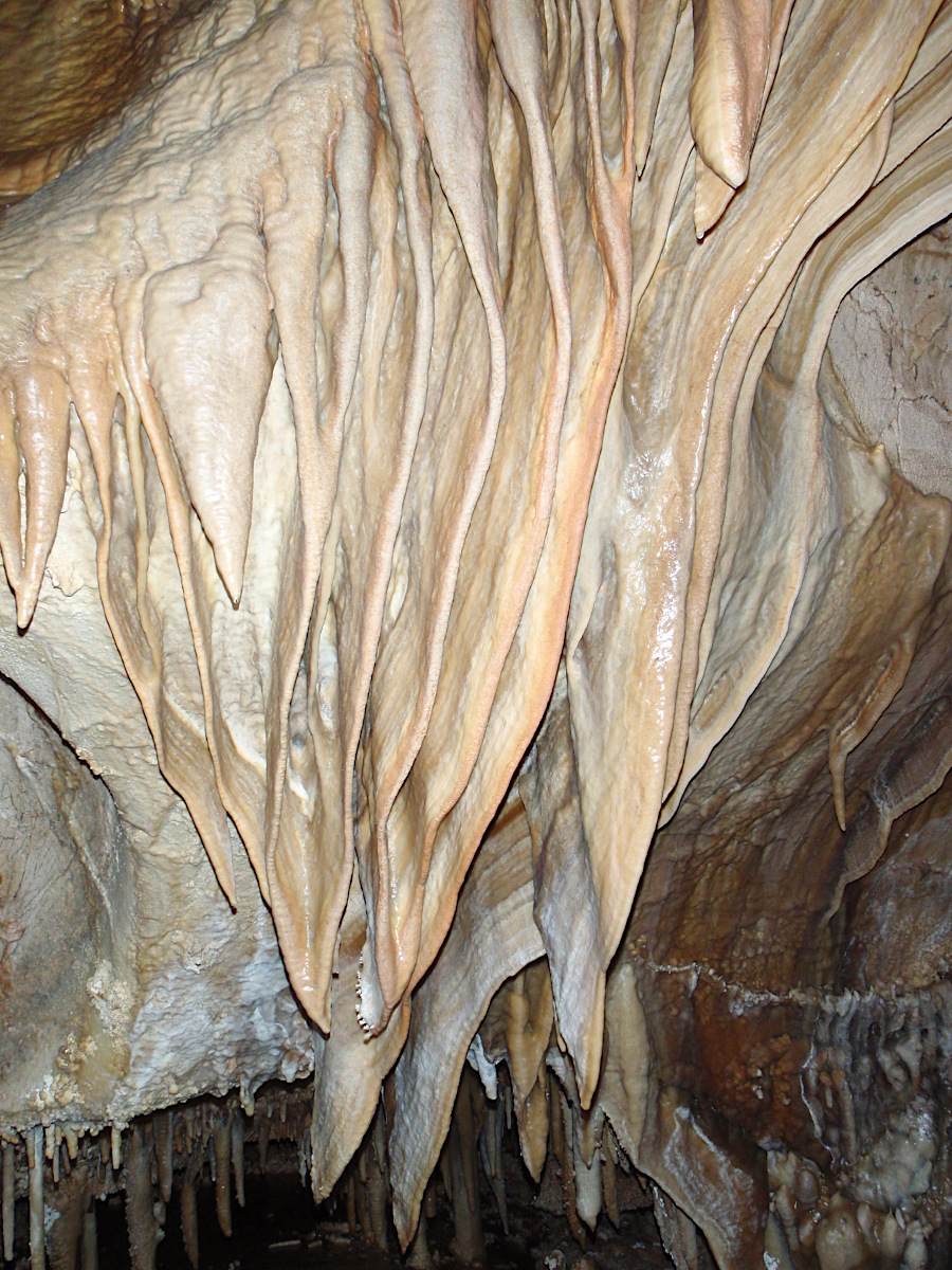 water saturated with calcium carbonate, evaporating in a cave, can create speleothems such as draperies