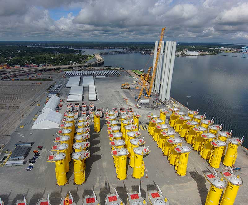 the four parts of the white turbine towers were stacked at the Portsmouth Marine Terminal for transport by Charybdis